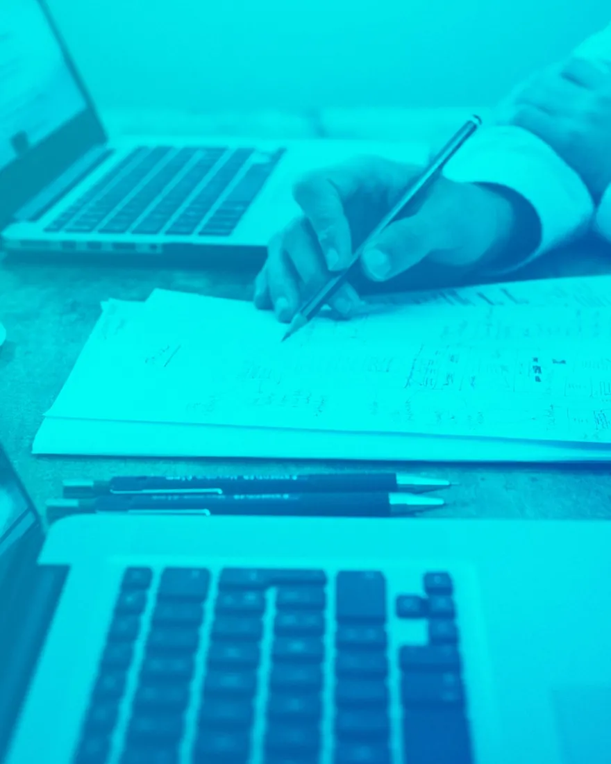 Blue duotone: handwritten notes beside a laptop keyboard